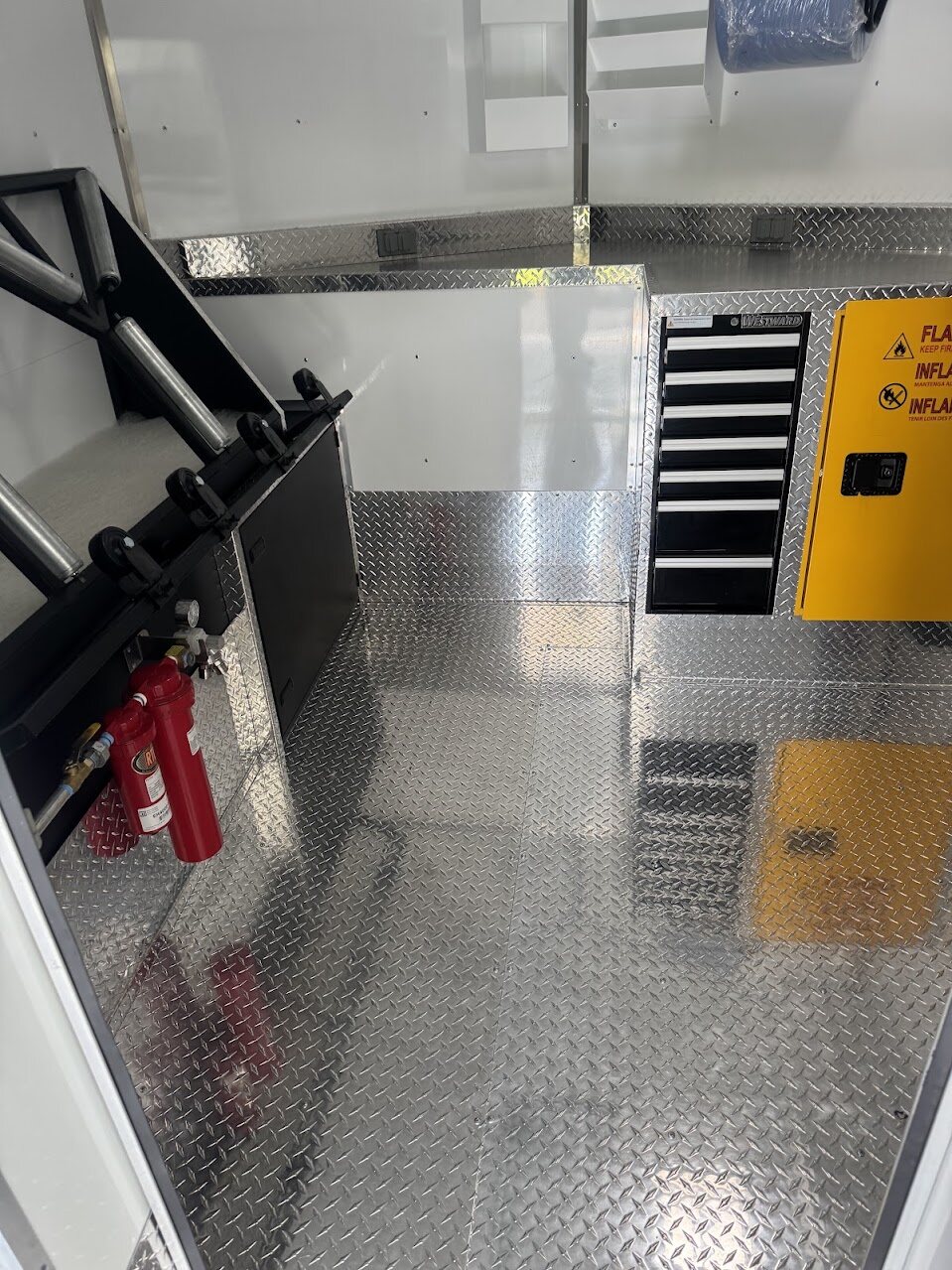 Paint booth inside the Rim Revival trailer with a downdraft table and overspray filter